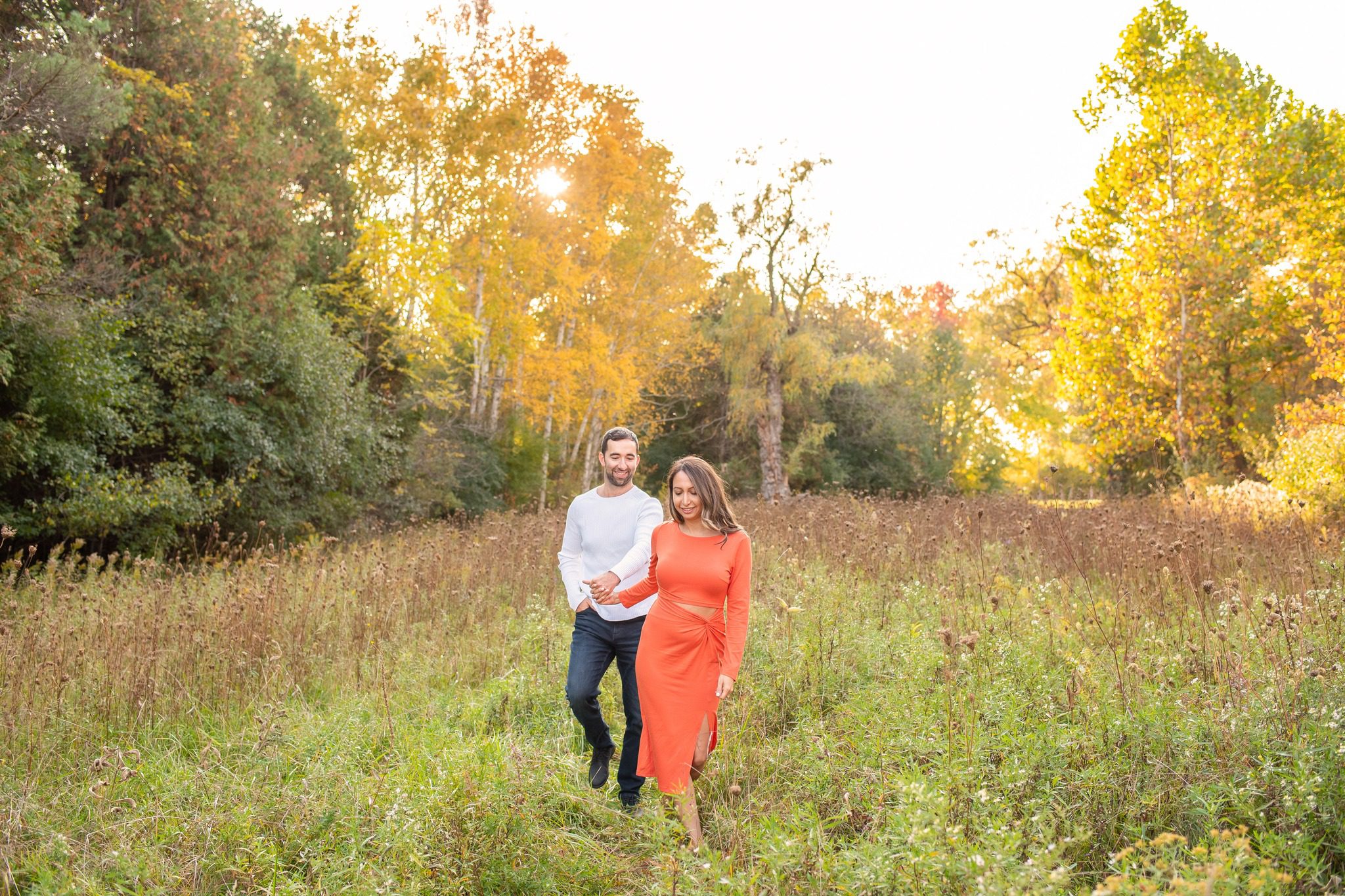 couple walking together through fall field at Fanshawe Conservation Area