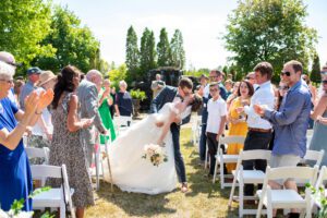 bride and groom dip kissing down aisle