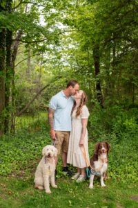 Couple kissing with their dogs at Springbank Gardens in London Ontario.