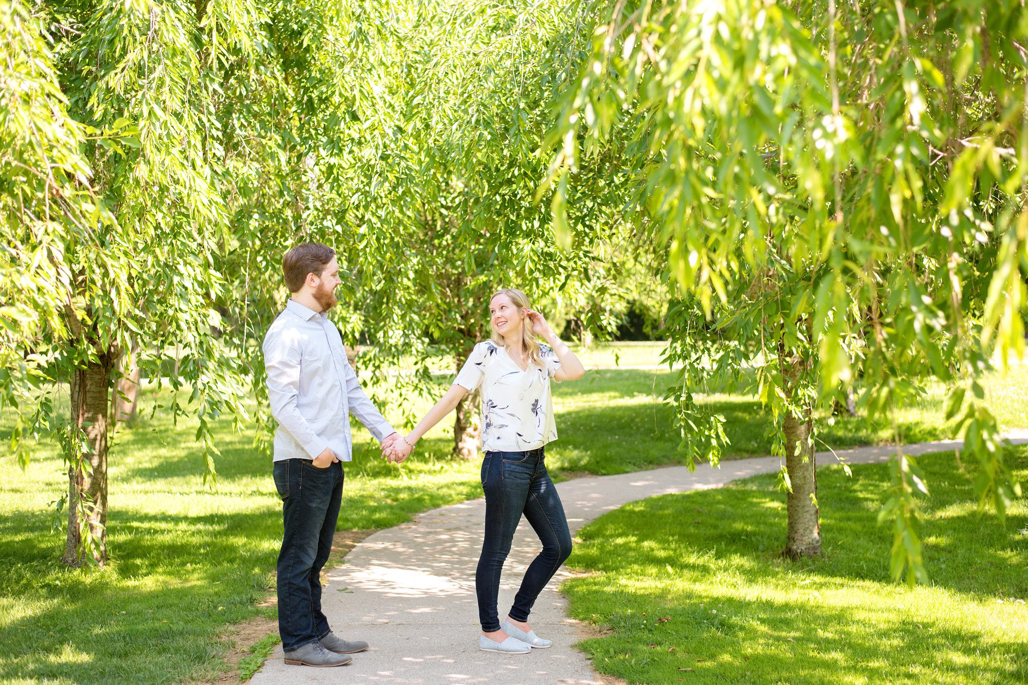 couple holding hands on pathway in the summer