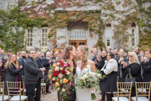Brides kissing at the end of the aisle at The Old Court House.