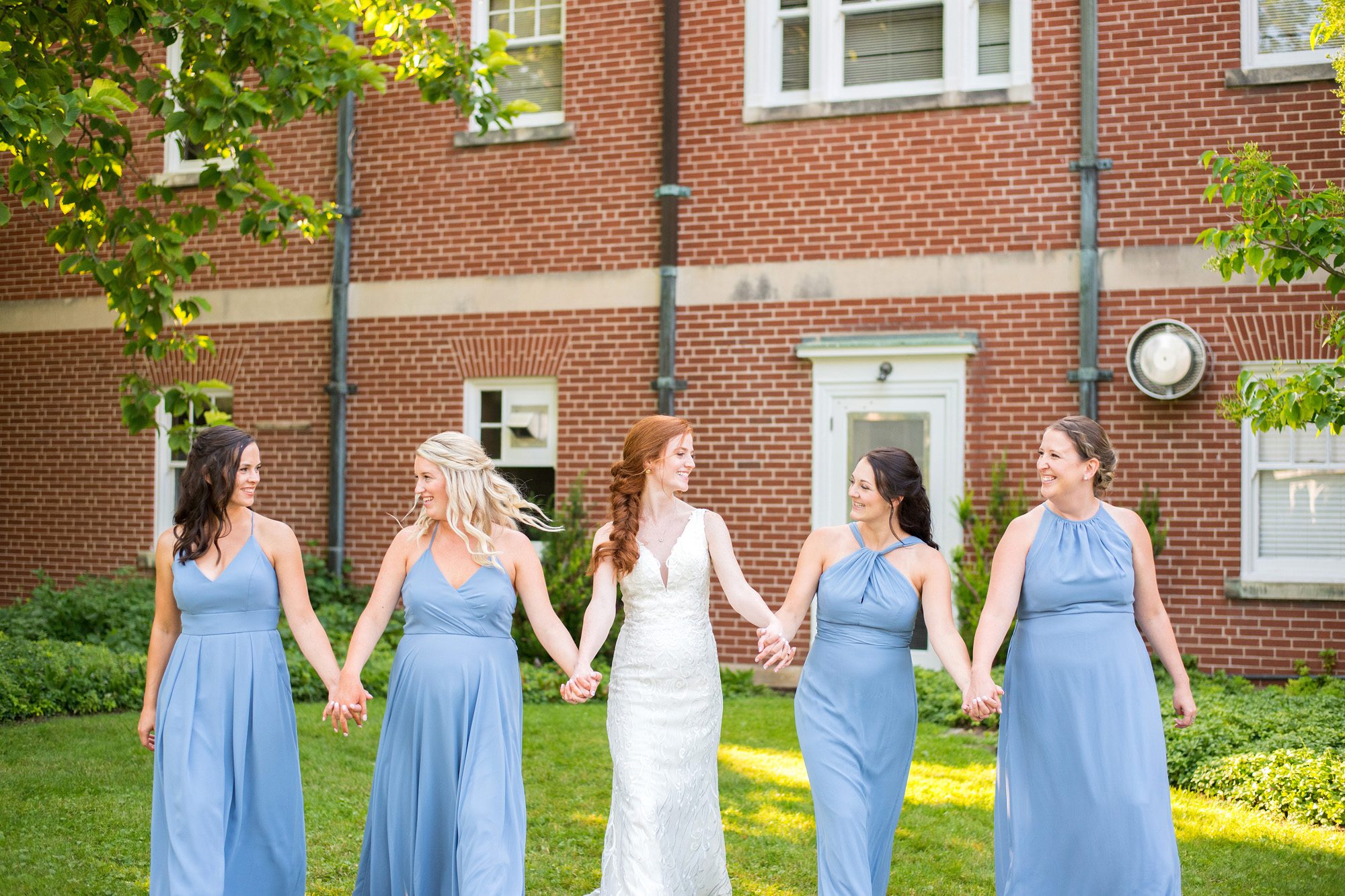Bride and bridesmaids walking and smiling at each other at Ivey Spencer Leadership Centre.