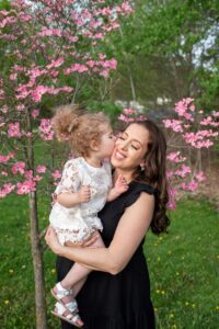 Little girl kissing pregnant moms cheek at Springbank Gardens