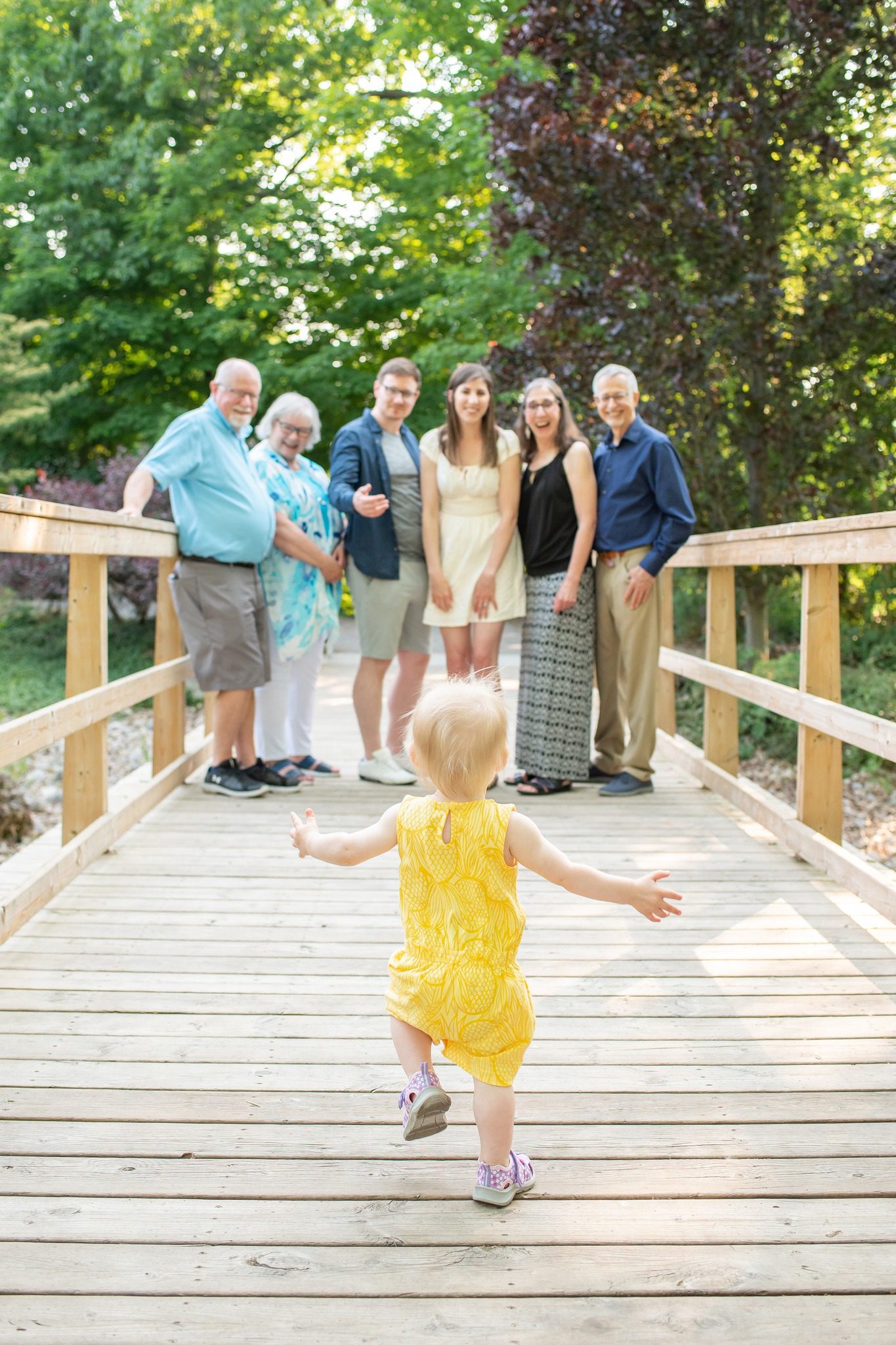 Little girl running towards family on bridge at Civic Gardens