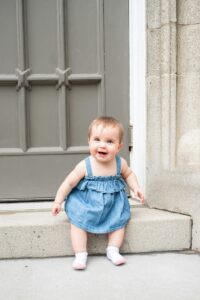 8 month old girl sitting on step giggling in Woodstock Ontario