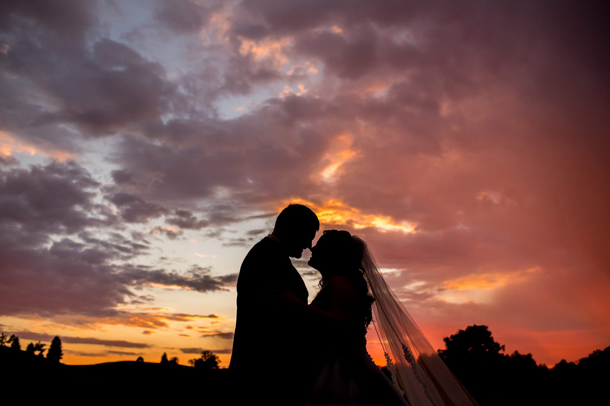 silhouette of bride and groom during sunset