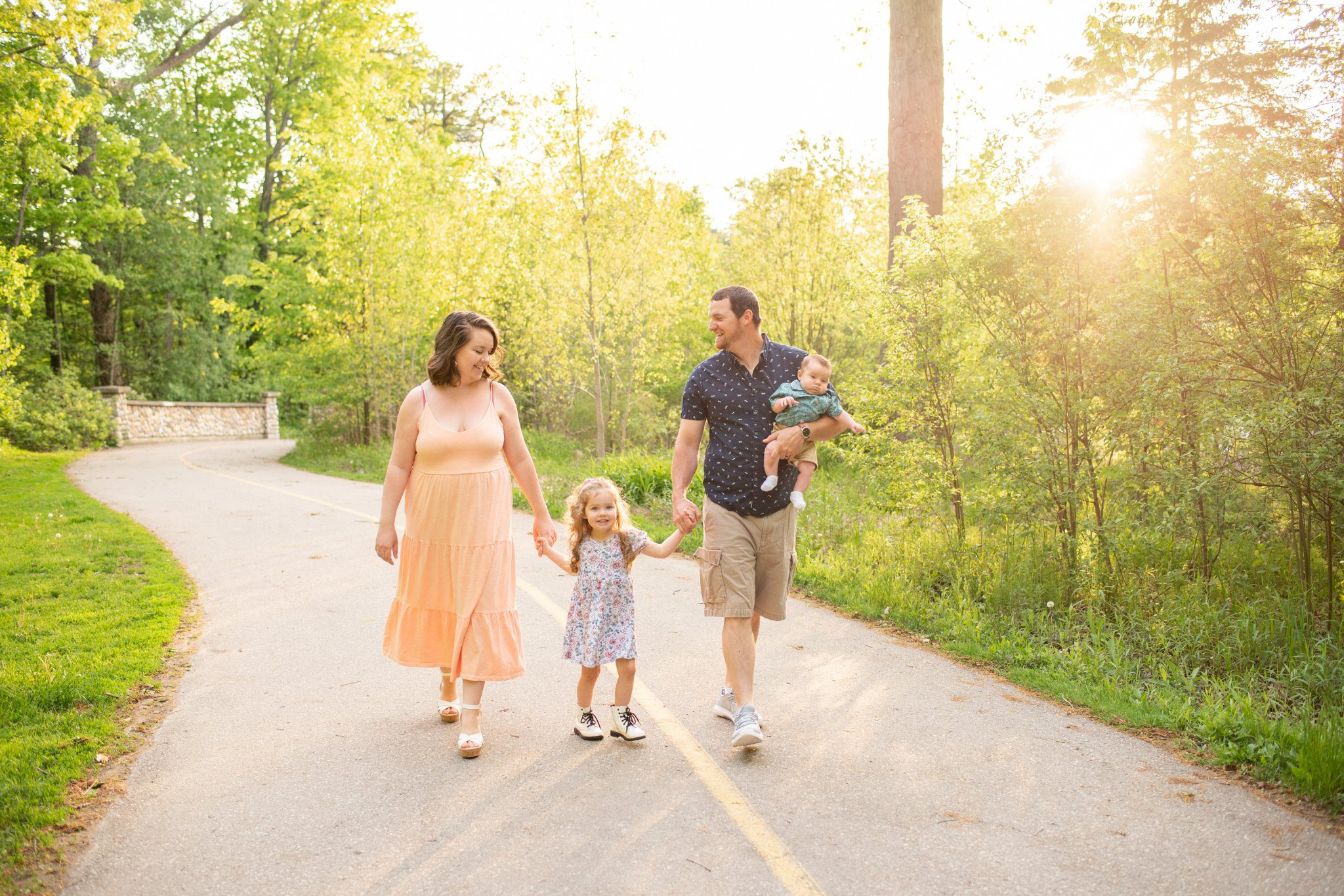 Family of 4 walking down path at sunset