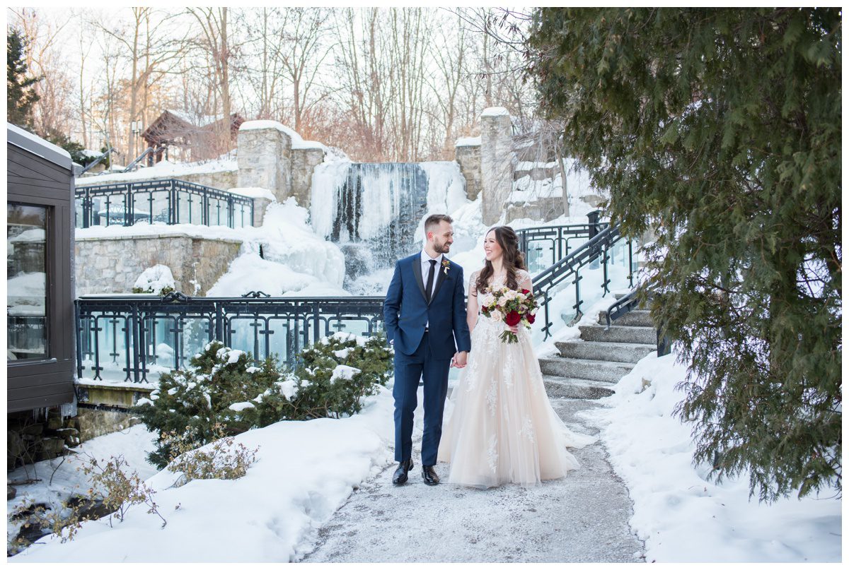 bride and groom walking along wintery pathway