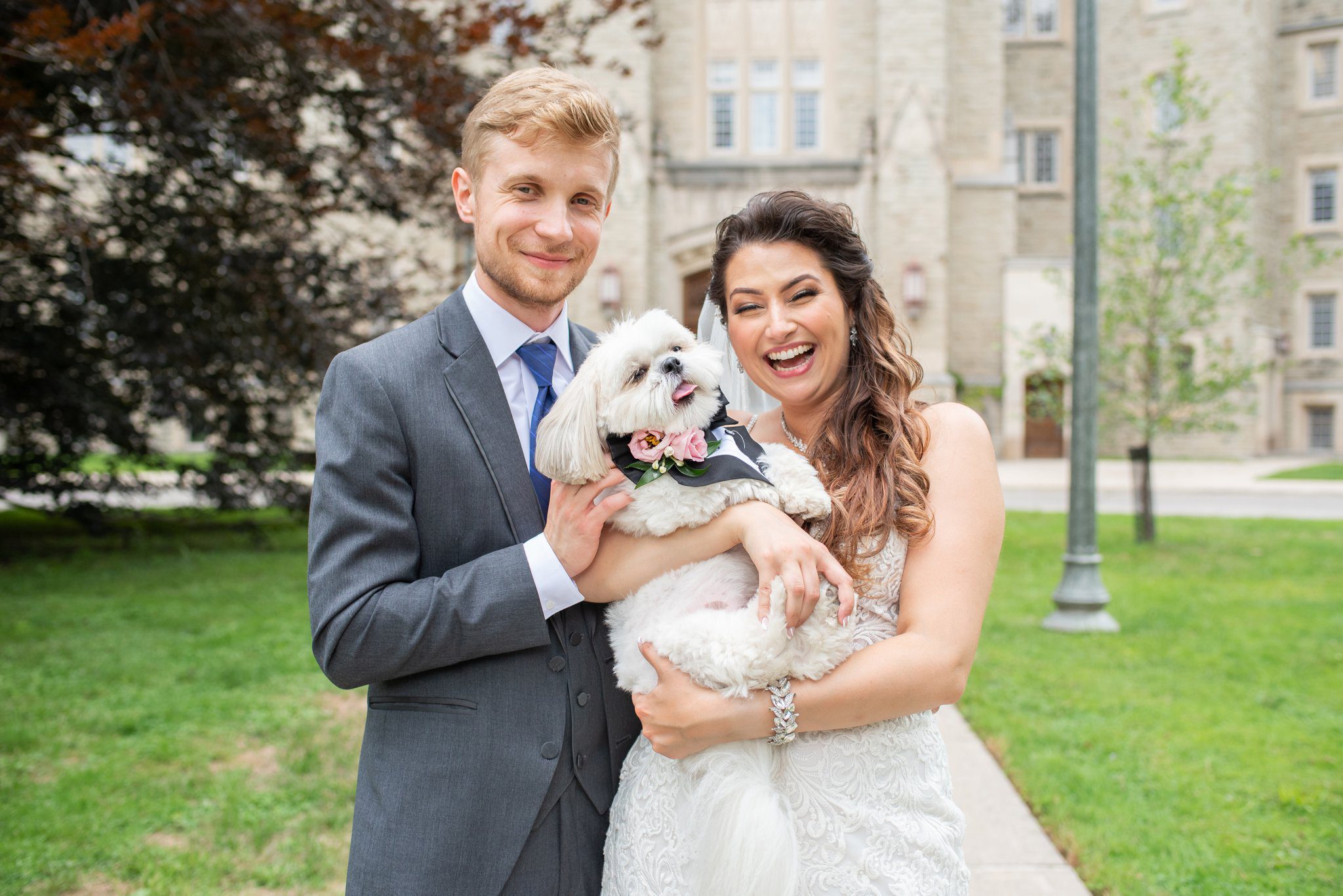 Bride and groom holding their dog.