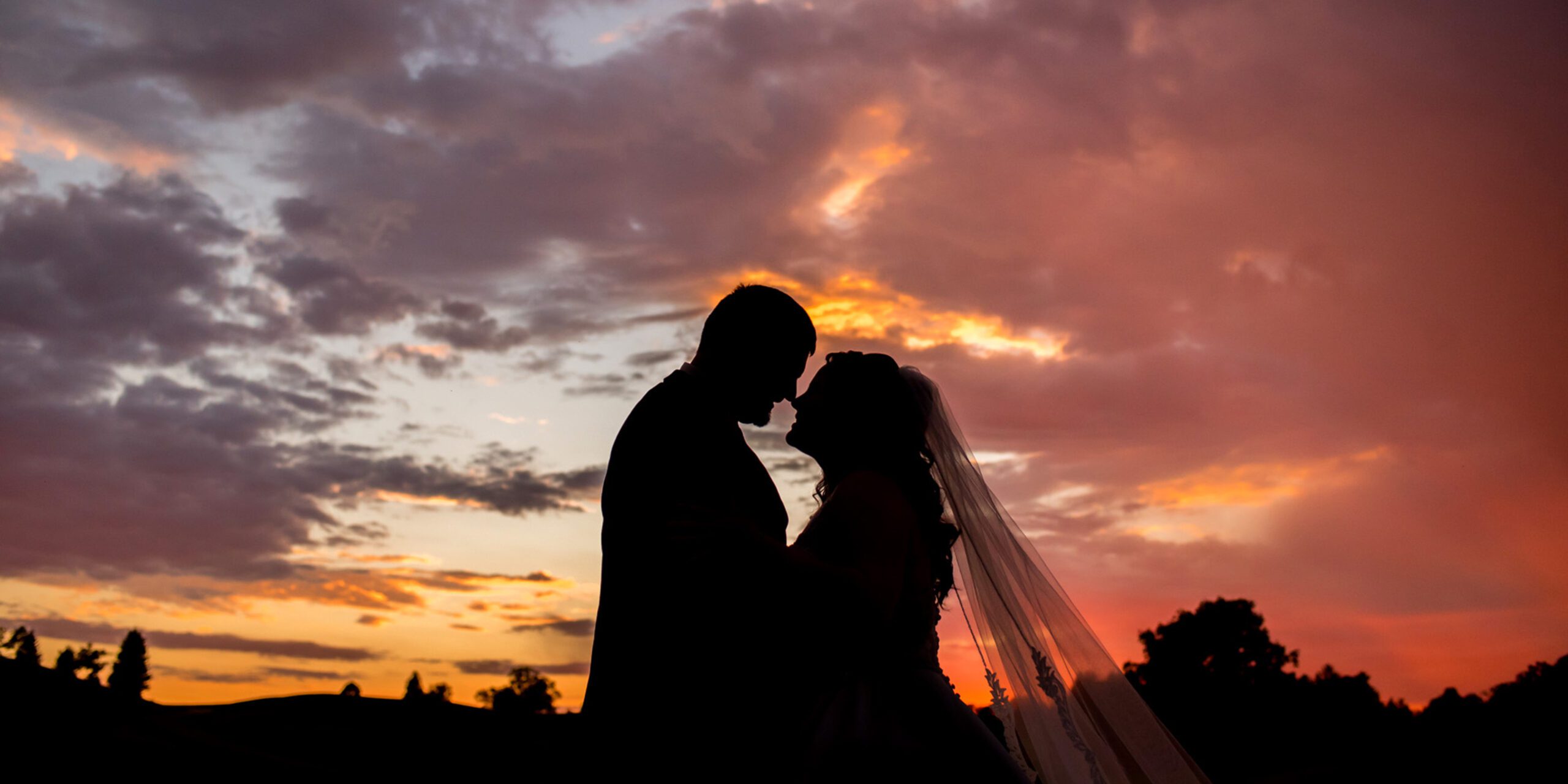 Silhouette of bride and groom in front of sunset at Whistle Bear.