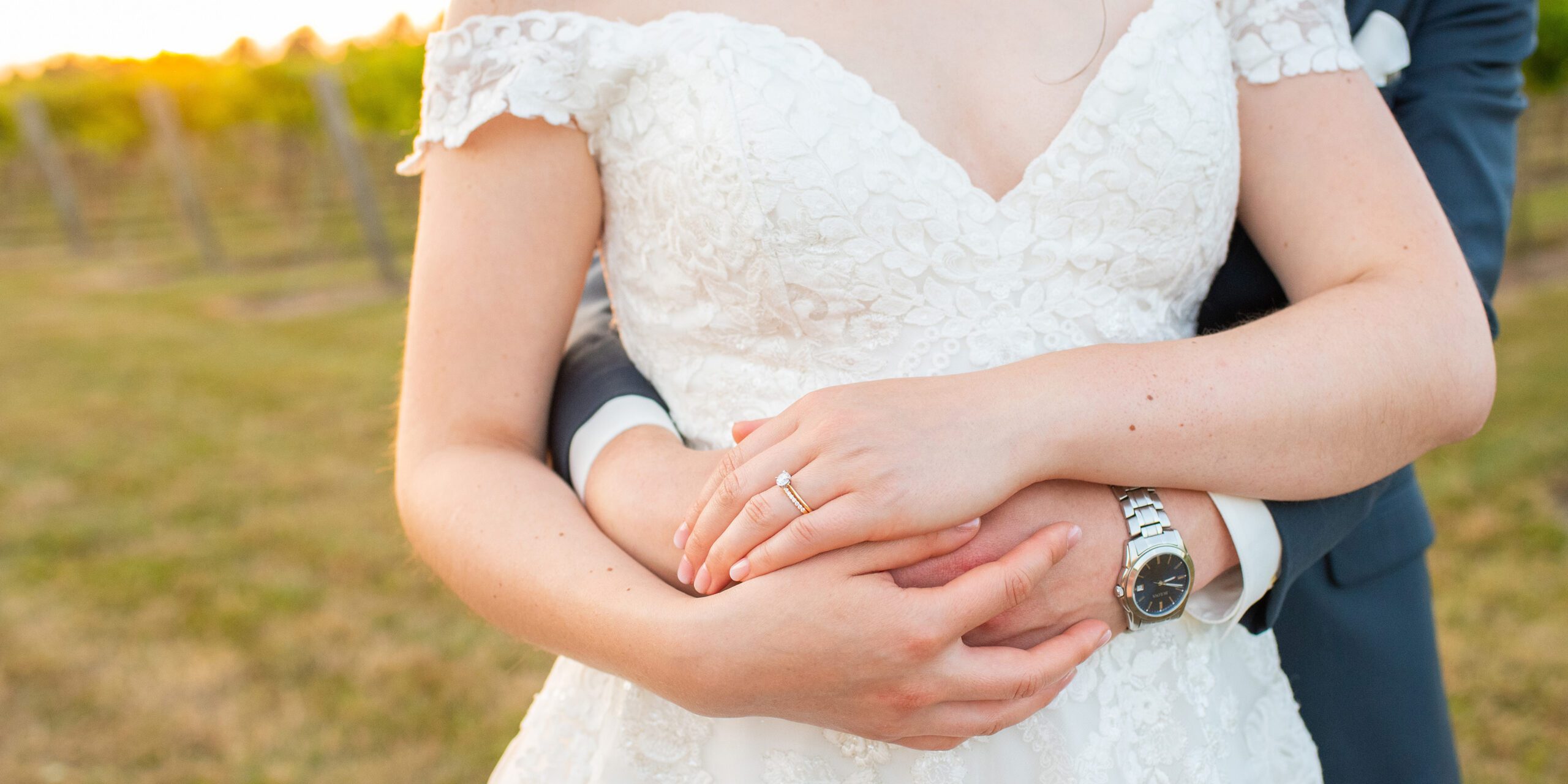Close up of brides rings as groom hugs her from behind at Hessenland Inn and Spa.