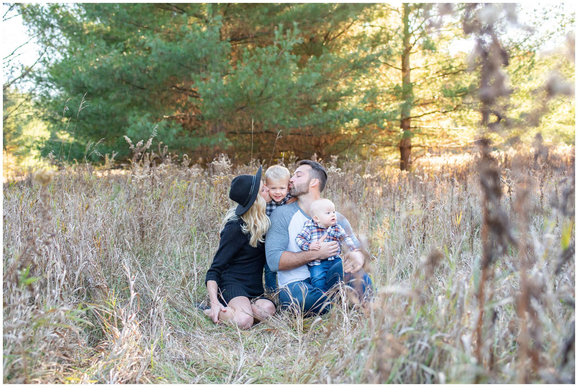Family of 4 sitting in fall grass at Komoka Provincial Park.How to keep family photos fun & easy