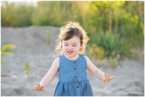 Girl on beach playing with sand in Port Stanley Ontario