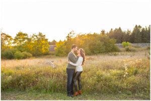 couple facing each other in front of field during sunset at Fanshawe Conservation Area