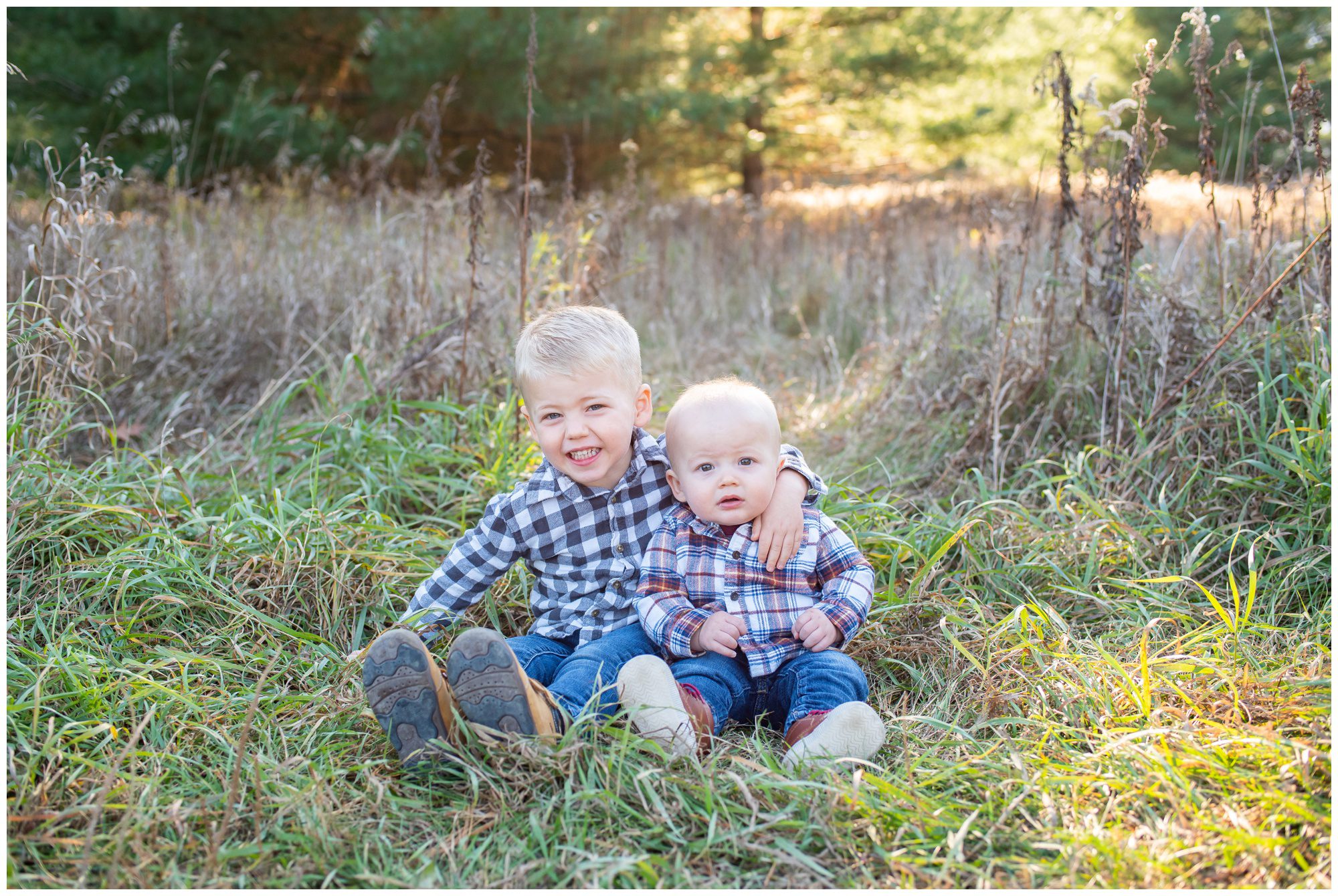 Two toddler boys sitting in field at Komoka Provincial Park