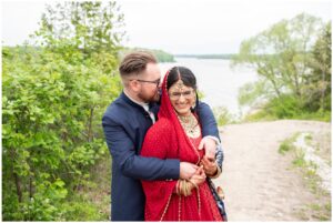Groom kissing bride from behind in traditional Indian outfits at Forest City National in London Ontario