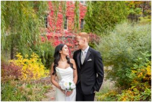 Wedding couple looking at each other surrounded by fall foliage at Western University
