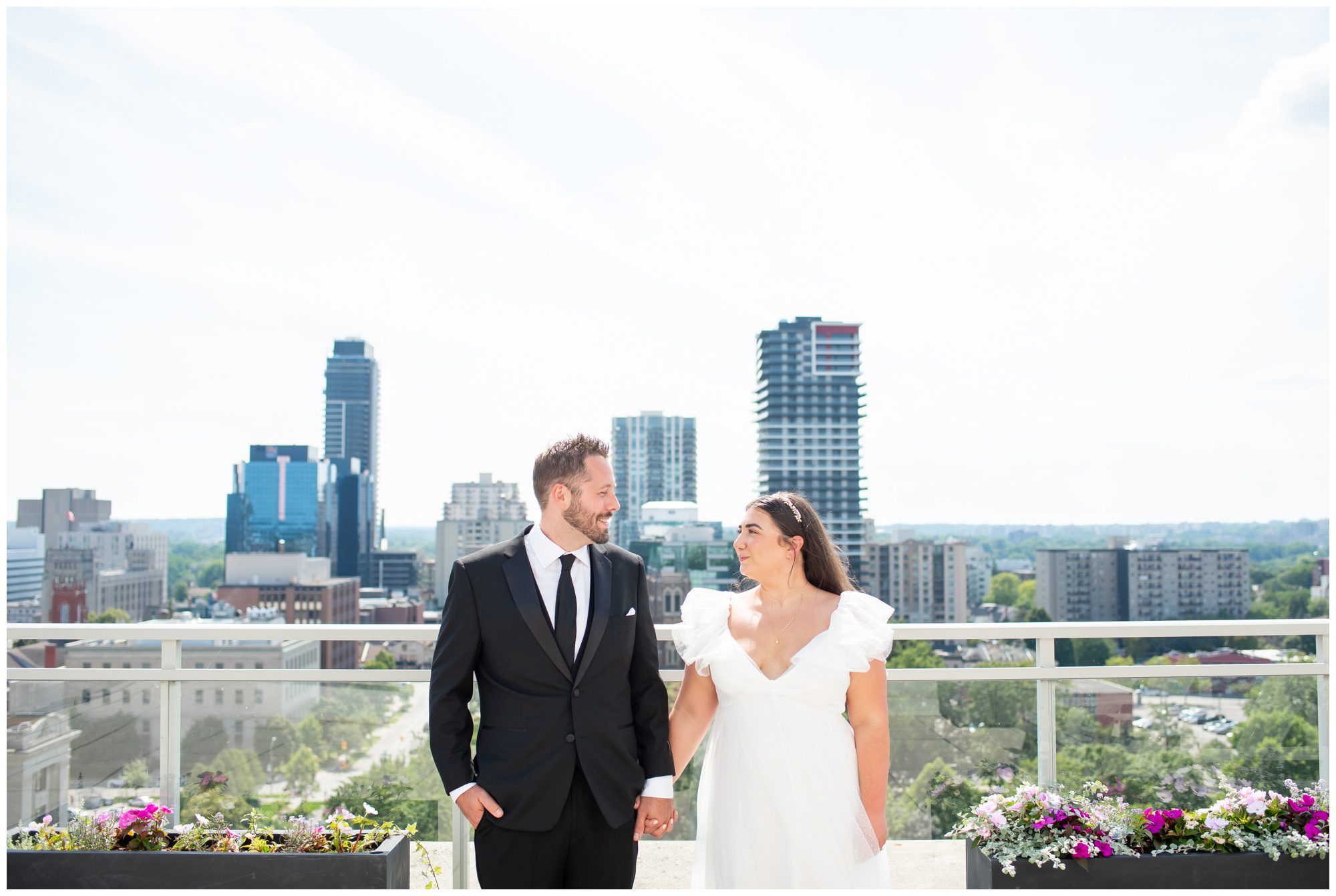 Bride and Groom on the roof of London Ontario City Hall with downtown London in the background.