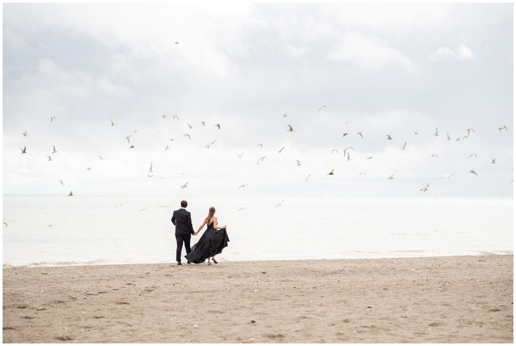 Couple walking away long the beach at Port Stanley Ontario.
