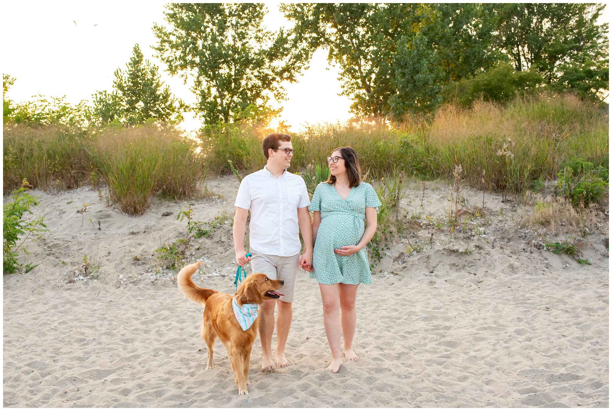 Couple walking on the beach together with their dog in Port Stanley Ontario.
