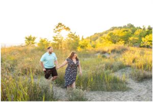 Couple walking through the sand dunes at golden hour at Erie Rest Beach in Port Stanley.