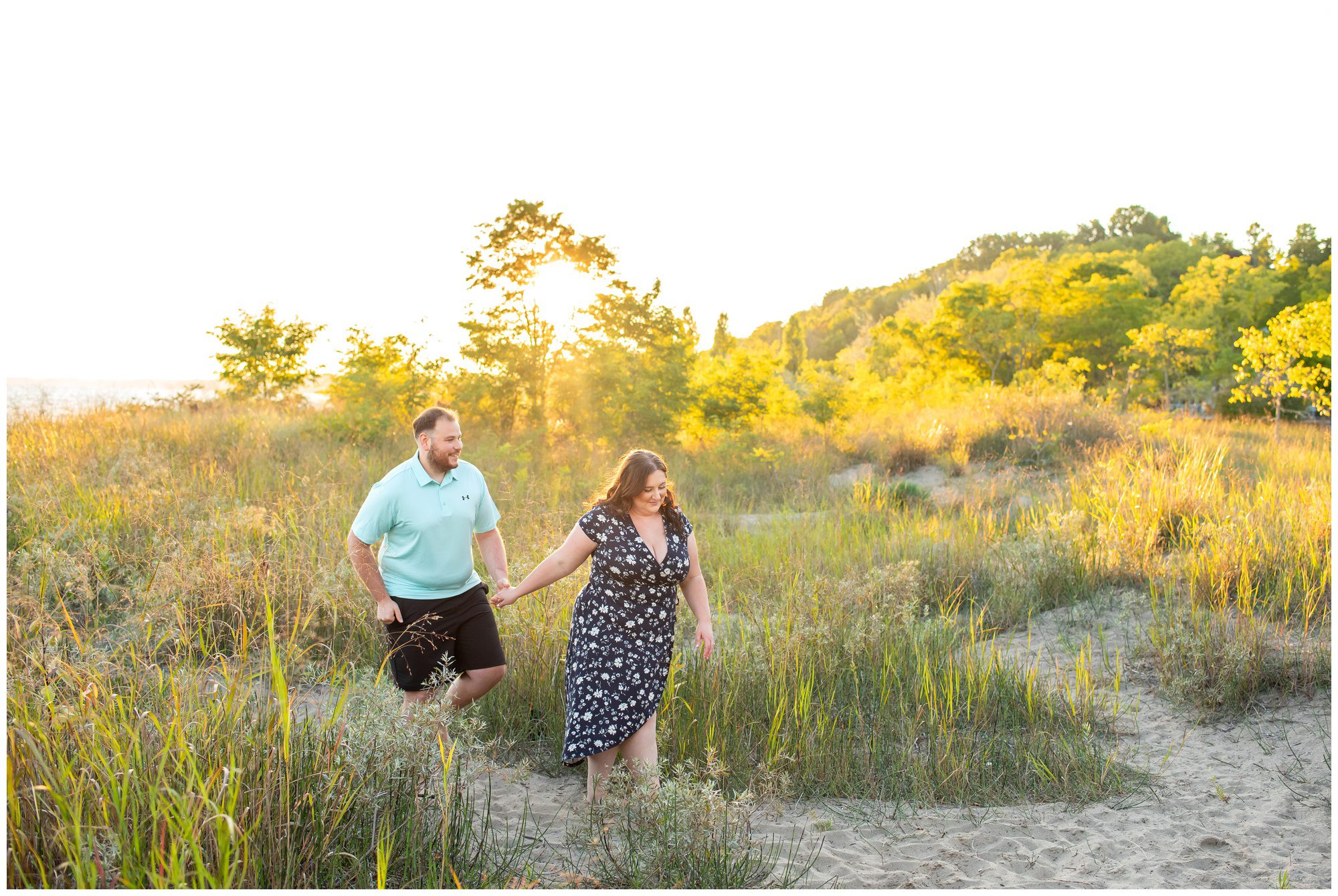 Couple walking through the sand dunes at golden hour at Erie Rest Beach in Port Stanley.
