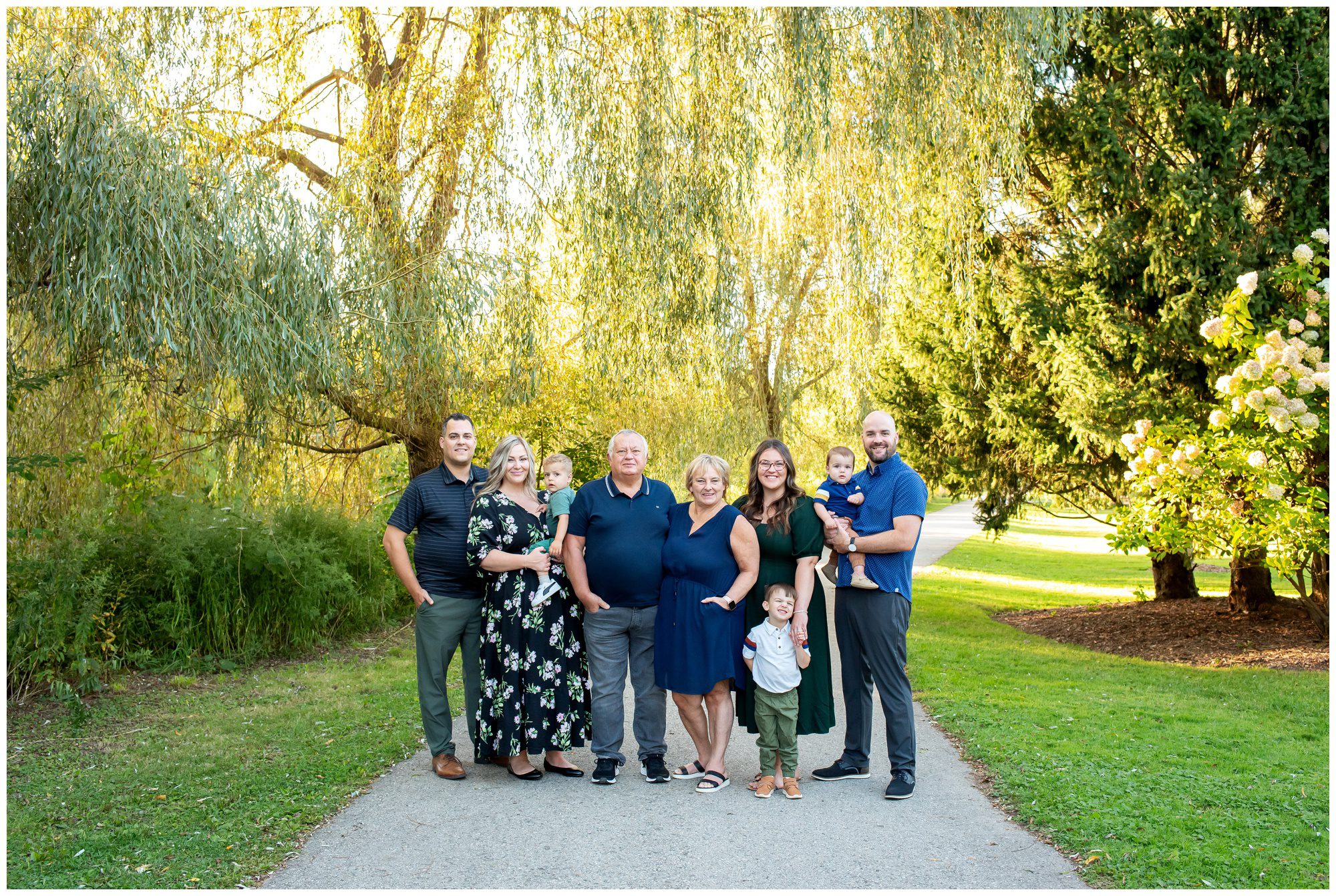 Family looking at the camera and smiling together at Waterworks Park in St Thomas Ontario.